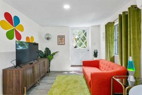 a living room with a red chair and a television at That 70’s Themed Apt Close to Coffee, Food + Shops in Tampa