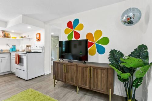 a kitchen with a flat screen tv on a wall at That 70’s Themed Apt Close to Coffee, Food + Shops in Tampa