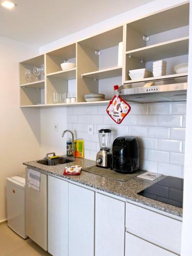 a kitchen with white cabinets and a counter top at Departamento amoblado en Luque in Luque