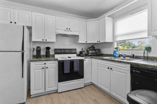a kitchen with white cabinets and a black appliance at Zebra House - Close 2 all TampaBay has to offer in Tampa