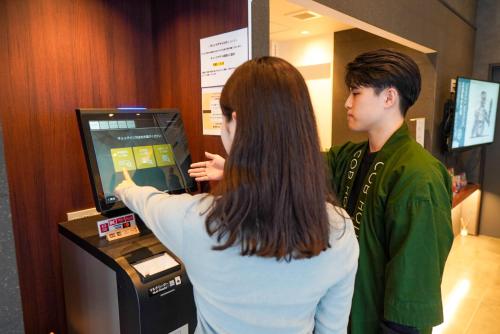 a man and a woman playing a video game at COB HOTEL Asakusa in Tokyo