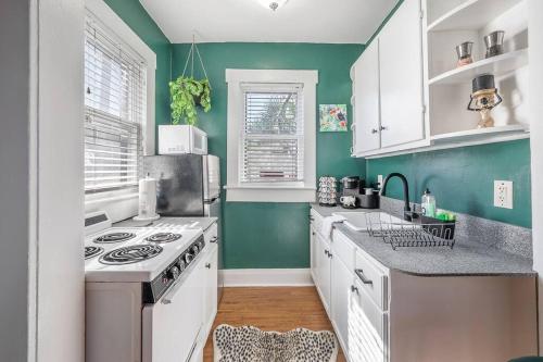 a kitchen with green walls and a stove top oven at Jungle Themed Apt. Close to Coffee, Food + Shops! in Tampa