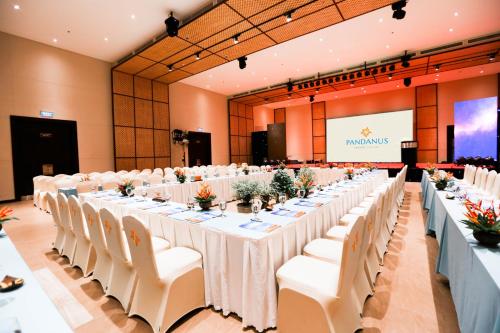 a large banquet hall with white tables and white chairs at Pandanus Resort in Mui Ne