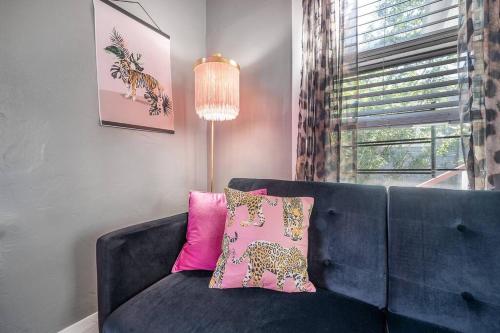 a living room with a blue couch and a window at Jungle Themed Apt. Close to Coffee, Food + Shops! in Tampa