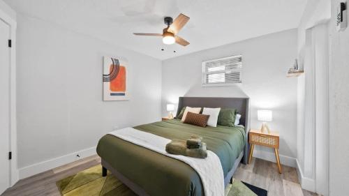 a bedroom with a green bed with a ceiling fan at Modern-Retro Themed Home Close to Coffee + Food! in Tampa