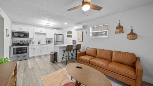 a living room with a couch and a kitchen at Modern-Retro Themed Home Close to Coffee + Food! in Tampa