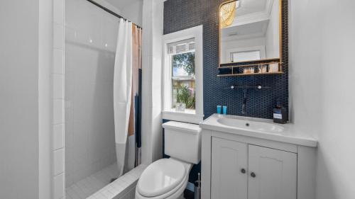 a bathroom with a toilet and a sink and a mirror at Comfy Modern Farmhouse Cottage w/ Private Patio! in Tampa