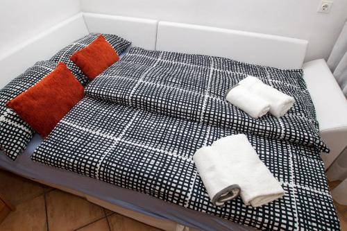a black and white bed with towels and pillows at Top Line Apartments in Piran