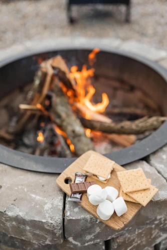 a board with marshmallows and crackers in front of a fire at Modern Cabin with Luxury Gym, Firepit + Game Room! in Blue Ridge