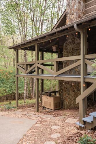 a pavilion outside of a house in the woods at Modern Cabin with Luxury Gym, Firepit + Game Room! in Blue Ridge