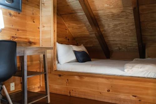 a small bed in a room with wooden walls at Modern Cabin with Luxury Gym, Firepit + Game Room! in Blue Ridge