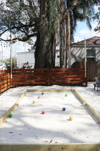 a play area with balls on the ground in front of a tree at Outdoor Hangout with BBQ, Firepit, Bocce Ball and More in Tampa