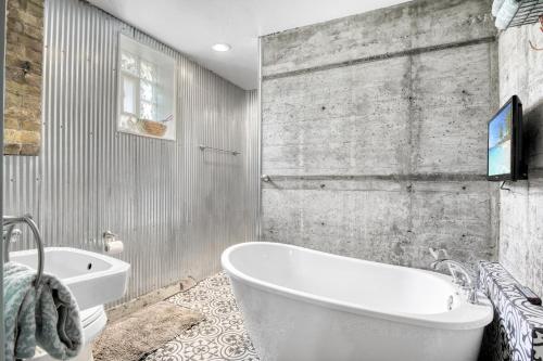 un bagno con una vasca bianca e un lavandino di Holy Smokes, what a stay! Spacious church convert a Sturgeon Bay