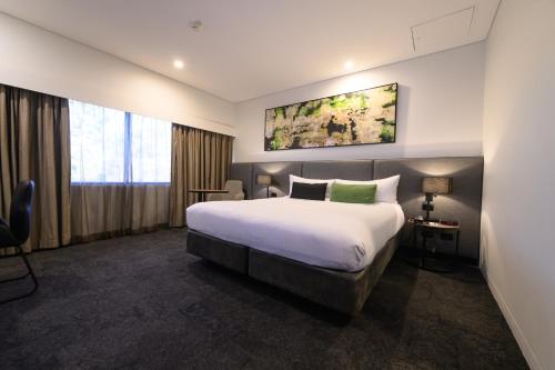 a hotel room with a large bed and a window at Mercure Penrith in Penrith