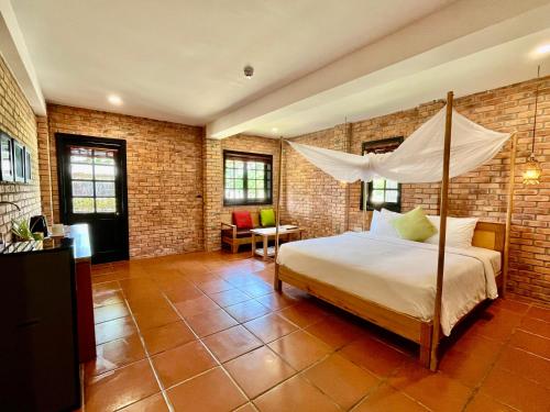 a bedroom with a bed with a canopy at ENSO Retreat Hoi An - Rediscovery & Serenity in Hoi An