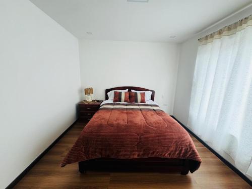 a bedroom with a bed in a white room at Casa SC in Azogues