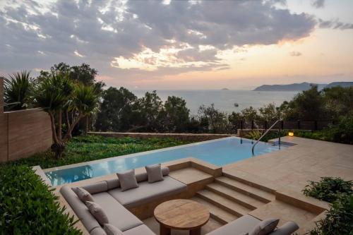 a swimming pool with a couch and a table at Alila Dong'Ao Island Zhuhai in Zhuhai