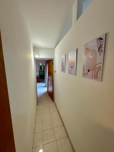 a hallway with paintings on the walls of a house at Casa Amplia en Ruta del vino in Ciudad Lujan de Cuyo