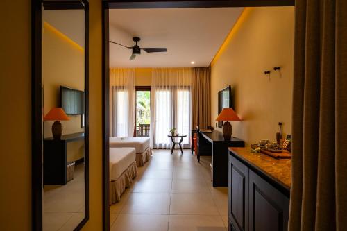 a hotel room with a bed and a bathroom at Pandanus Resort in Mui Ne