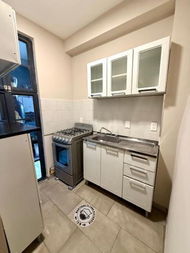 a kitchen with white cabinets and a stove top oven at RMS Suites - Zona Rosa in Mexico City