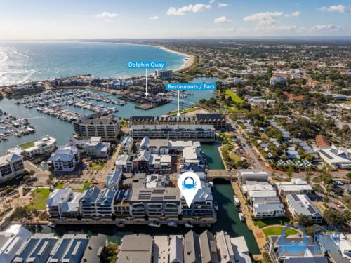 an aerial view of a marina with condos and the ocean at Coastal Canal Retreat in Mandurah in Mandurah