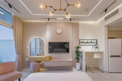 a living room with a couch and a tv at Damac Hills Carson studio on Golf Course in Dubai Marina
