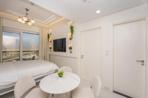 a bedroom with a bed and a table and chairs at Designer 1BR I Golf View I Comfortably Sleeps 4 in Dubai