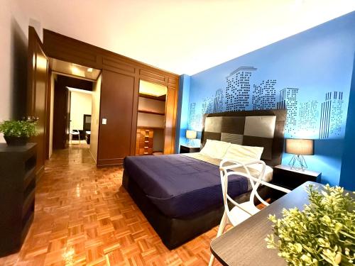a bedroom with a bed and a blue wall at RMS Suites - Zona Rosa in Mexico City