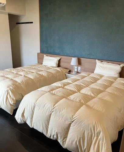 two beds sitting next to each other in a room at RYOKAN優勝館Hotel in Osaka