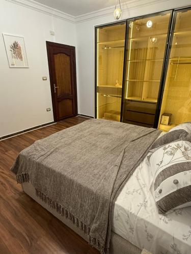 a bedroom with a large bed and a wooden floor at Tanta luxury apartments 2bed in Quḩāfah