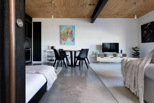 Bright Studio in Launceston CBD في Kings Park: غرفة نوم مع طاولة طعام وكراسي