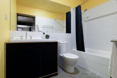 Bright Studio in Launceston CBD في Kings Park: حمام مع مرحاض ومغسلة وحوض استحمام