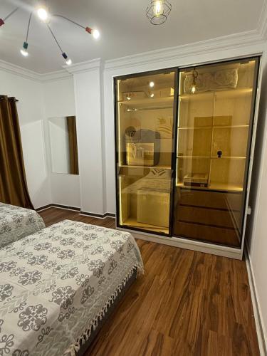 a bedroom with two beds and a glass wall at Tanta luxury apartments 2bed in Quḩāfah