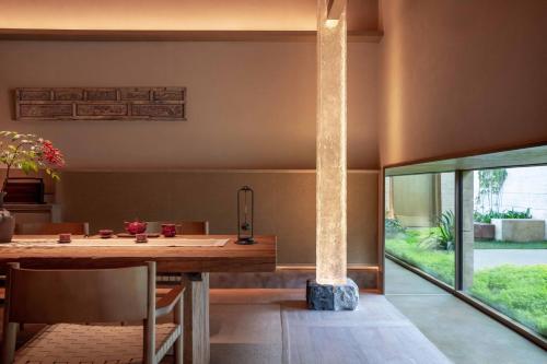 a dining room with a table and a large window at Alila Dong'Ao Island Zhuhai in Zhuhai
