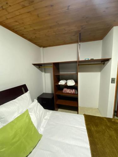 a bedroom with a white bed and a closet at Casa Santa María in Bogotá