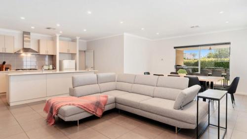 a living room with a couch and a kitchen at Estuary Break in Erskine in Falcon