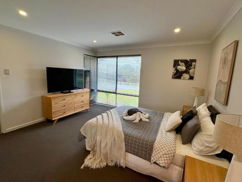 a bedroom with a large bed and a television at Estuary Break in Erskine in Falcon