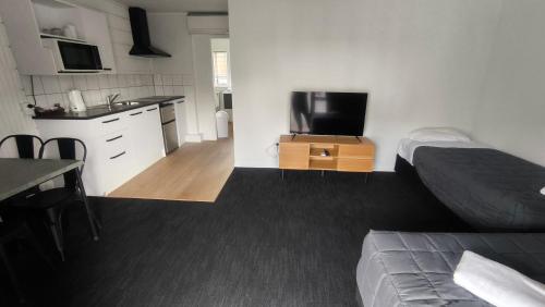 a bedroom with a bed and a kitchen with a tv at Pakuranga Motor Lodge in Auckland