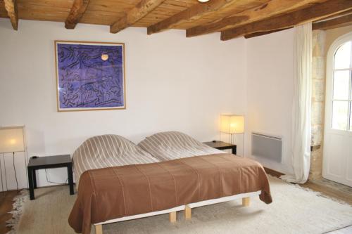 a bedroom with a bed and a painting on the wall at La Verte Dordogne in Villars