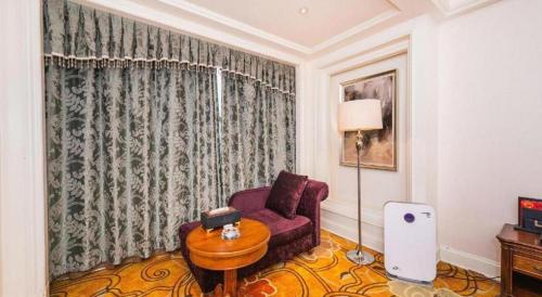 a living room with a purple chair and a table at Zhengzhou Yiquan International Hotel in Zhengzhou