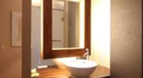 a bathroom with a white sink and a mirror at Griya Jogja Hotel in Yogyakarta