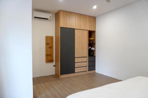 a bedroom with a bed and a wooden cabinet at KevilHome - Mini villa có hồ bơi in Da Nang