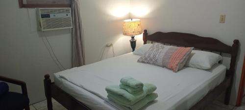 a bedroom with a bed with towels on it at Hacienda Tropical Guest House in Belmopan