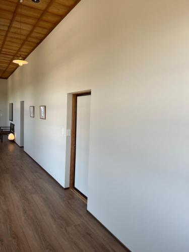 an empty room with a white wall and a door at 古民家ラグジュアリーホテル 金井西洋館 in Sado
