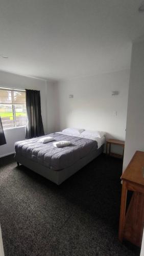 a bedroom with a bed in a room with a window at Pakuranga Motor Lodge in Auckland