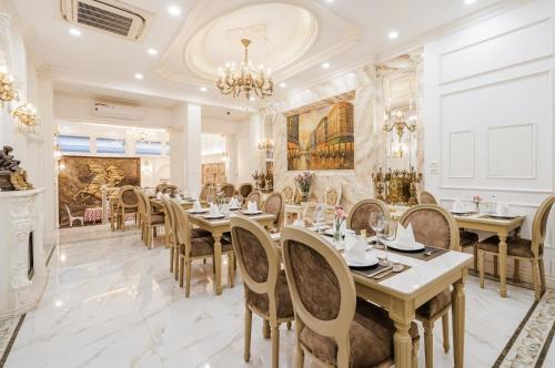 a dining room with tables and chairs and a chandelier at Delina Castle Coffee & Hotel in Hanoi