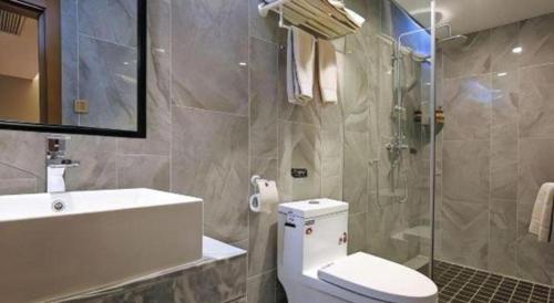 a bathroom with a toilet and a sink and a shower at Immersing Hotel Guilin Two Rivers and Four Lakes Dongxi Alley in Guilin