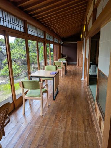 a room with chairs and tables and windows at RYOKAN優勝館Hotel in Osaka