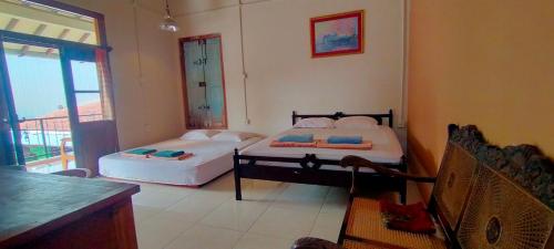 two beds in a room with a window at Bausasran52 in Yogyakarta