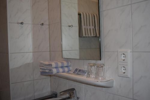 La salle de bains est pourvue d'un lavabo, d'un miroir et de serviettes. dans l'établissement Havergoh Wander- & Fahrrad-Hotel, à Horn-Bad Meinberg